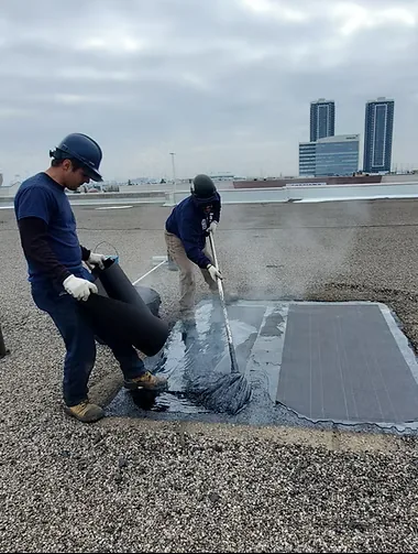 Delta Roofing crew applying a reflective restoration coating